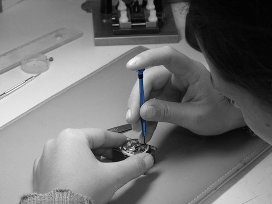 Horloger en train de réparer une montre à quartz