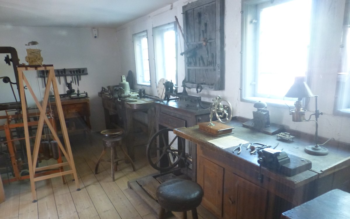 Atelier d'horlogerie ancien avec établis, outils et mécanismes — espace de travail d'un horloger