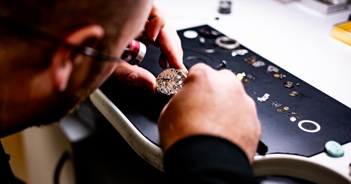 Horloger remplaçant la couronne d'une montre avec des outils de précision