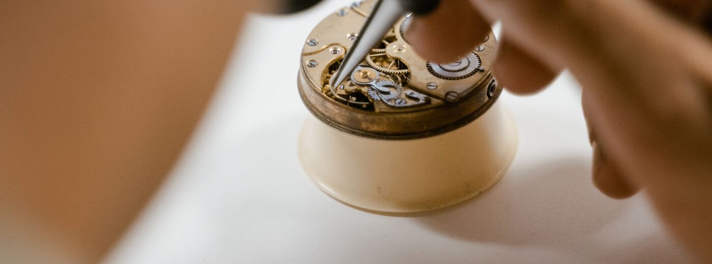 Horloger AGH au travail sur son établi : réparation d'un mouvement de montre confié par un professionnel