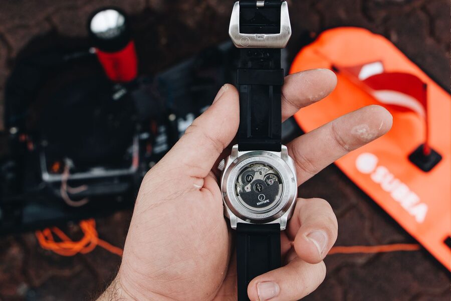 Montre automatique vue par le fond transparent : rotor et mouvement mécanique visibles — le remontage automatique alimente la réserve de marche