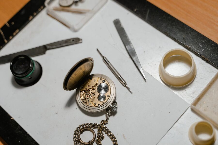 Montre de gousset ancienne ouverte sur un établi avec loupe et outils d'horloger — restauration de montres vintage en atelier