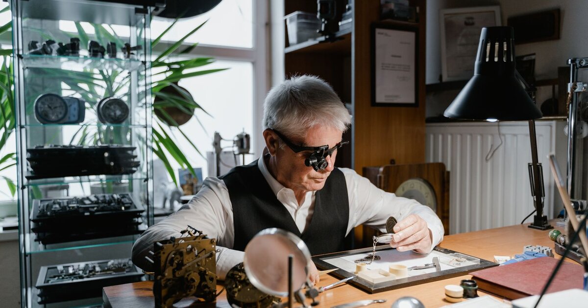 Horloger examinant une montre à la loupe dans son atelier — où faire réparer sa montre en France, le guide complet