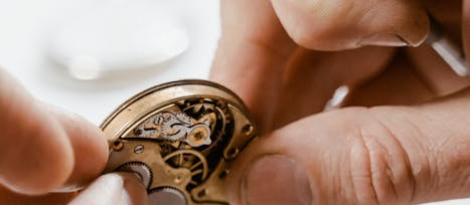 Réparation montre — mains horloger et outils