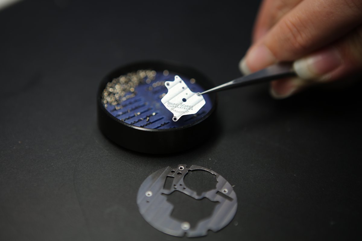 Révision montre automatique — horloger travaillant sur un mouvement mécanique