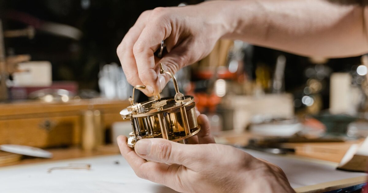 Horloger démontant un mouvement mécanique à la main sur son établi — révision complète de montre en atelier
